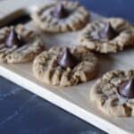 Overhead of peanut butter cookies on a cutting board with hershey kisses on top