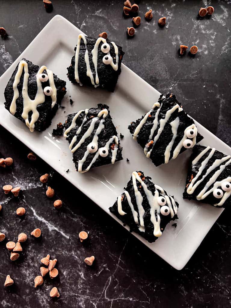 A close-up of delicious Black Cocoa Mummy Brownies topped with candy eyeballs, a spooky and sweet Halloween treat.