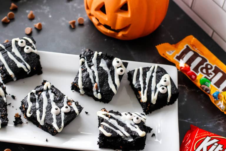 Spooky brownies with candy eye balls surrounded by jack-o-lanters and candy bars.