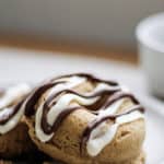 Golden-brown pumpkin protein donut on a white plate with Nutella drizzle