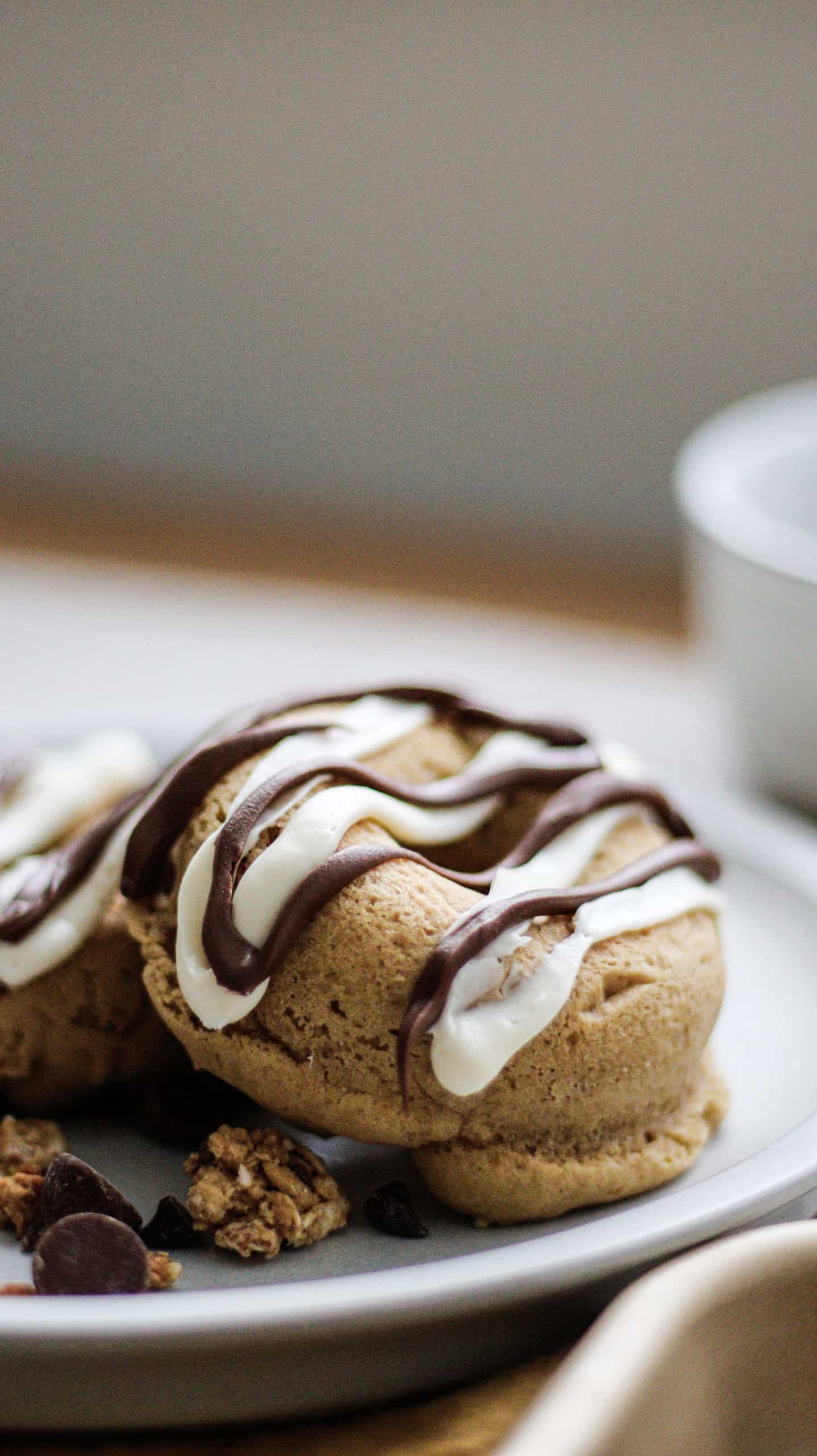 Golden-brown pumpkin protein donut on a white plate with Nutella drizzle