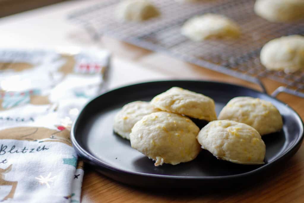 Orange glaze cookies plated on a black plate on a decorated holiday table
