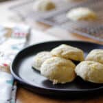 Orange glaze cookies plated on a black plate on a decorated holiday table