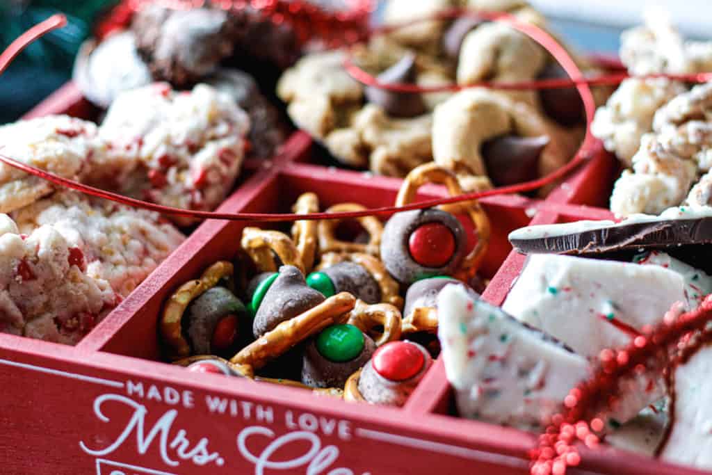 Red box full of various holiday treats, cookies and candy