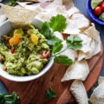 Guacamole in a bowl with chips on the side