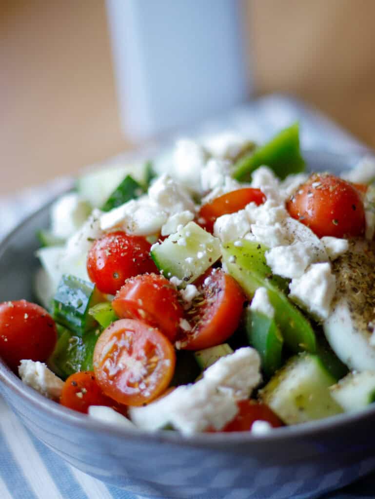 Close up of salad with tomatoes, feta cheese and cucumbers in a bowl