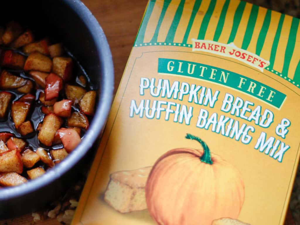 Cinnamon apples in a sauce pan next to a box of Trader Joe's Gluten Free Pumpkin Bread & Muffin Baking Mix