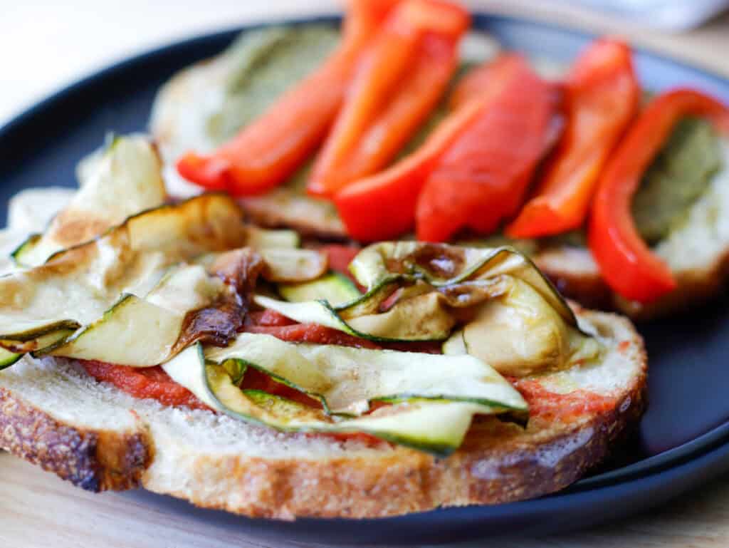 Thinly sliced zucchini ribbons on top of bread