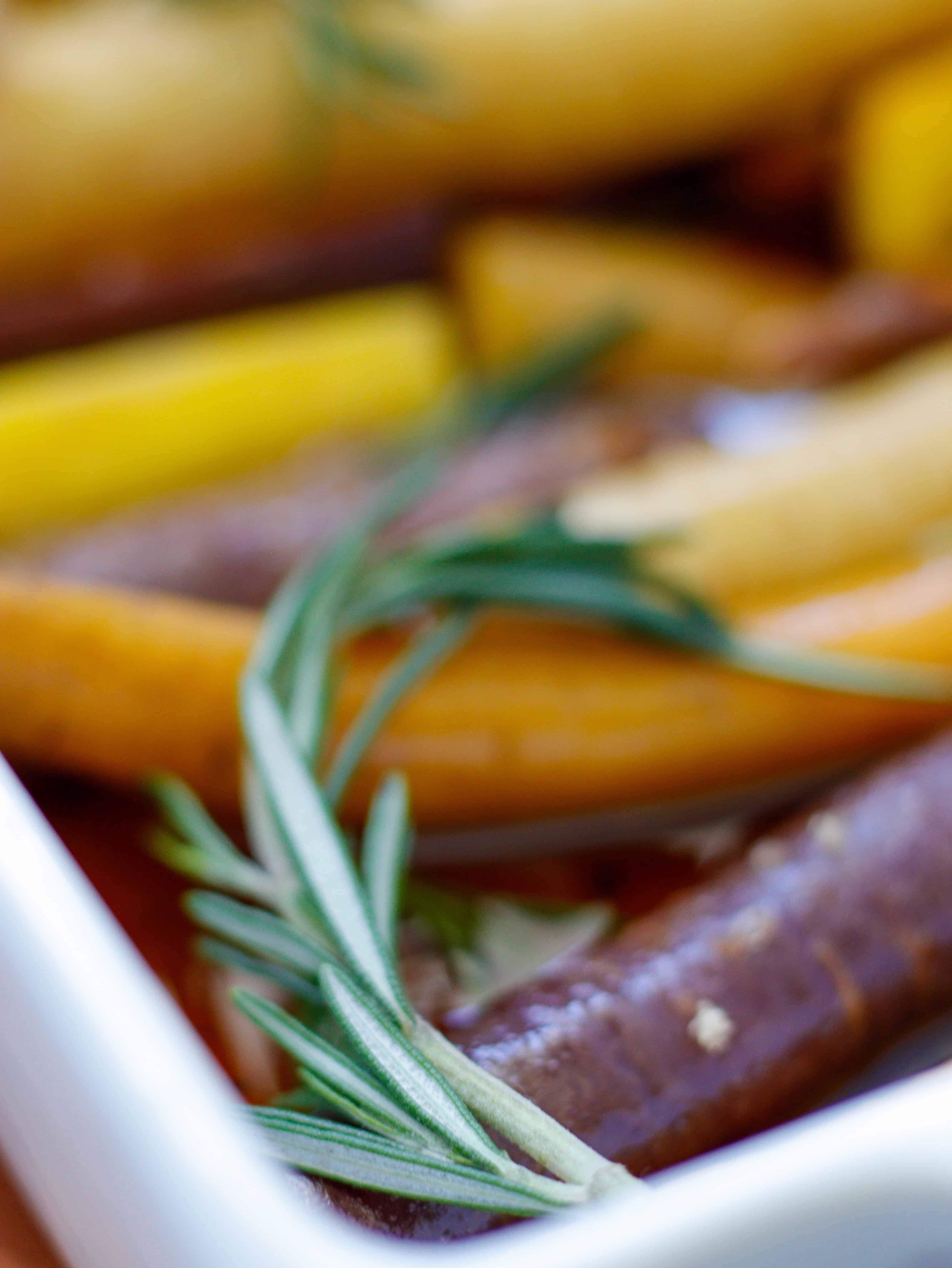 Sprig of rosemary on top of rainbow carrots