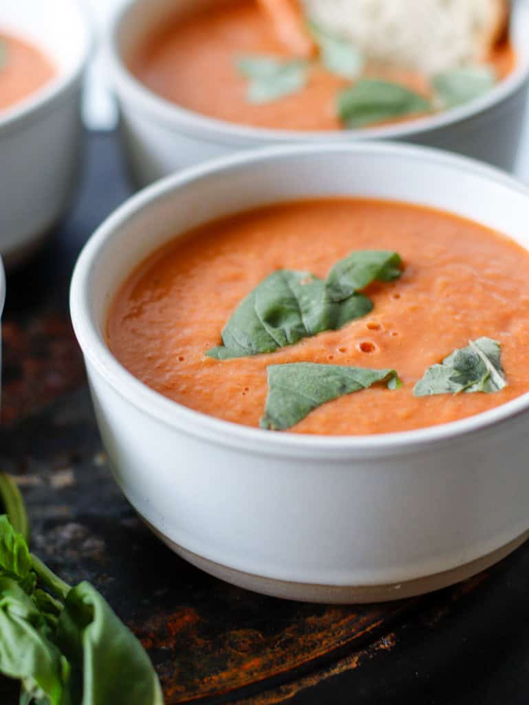 Bowl of tomato soup with basil sprinkled on top