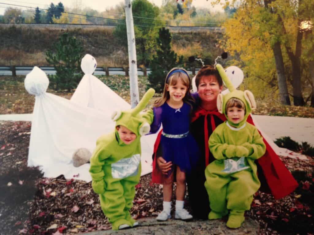 Kids in alien halloween costumes with ghost decorations in the background