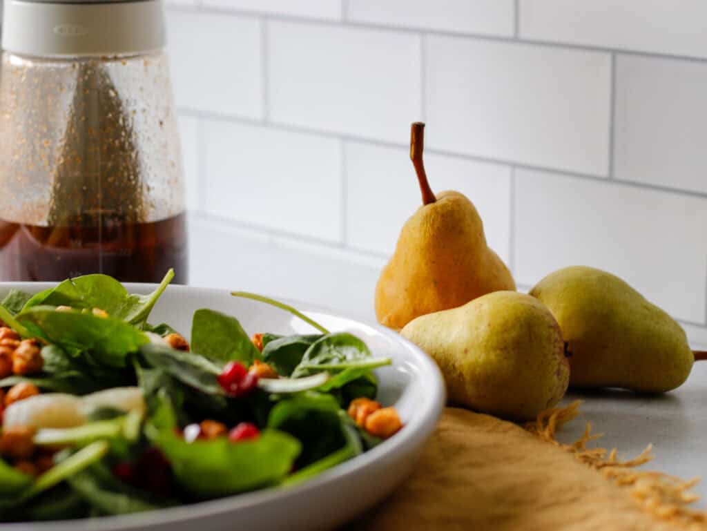 A fall side salad with a focus on pears sitting on the kitchen counter
