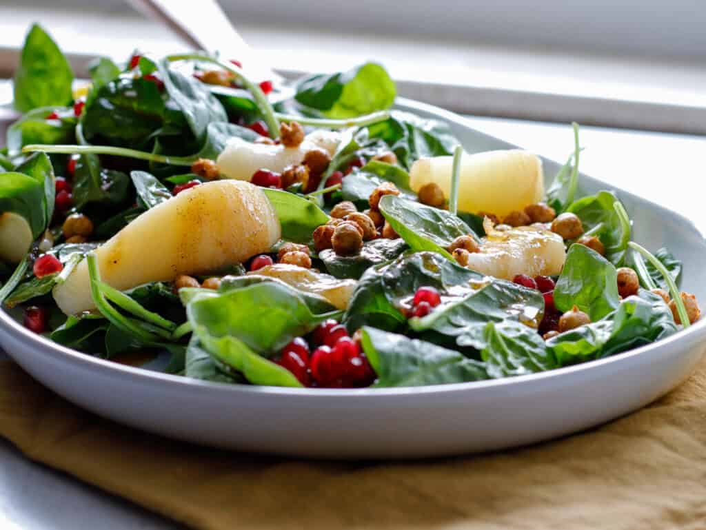 Spinach and pear salad plated with a yellow napkin