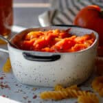 White bowl filled with homemade tomato sauce with dried pasta ready to cook.