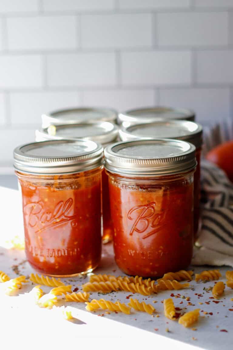 Mason jars filled with homemade tomato sauce on a counter top