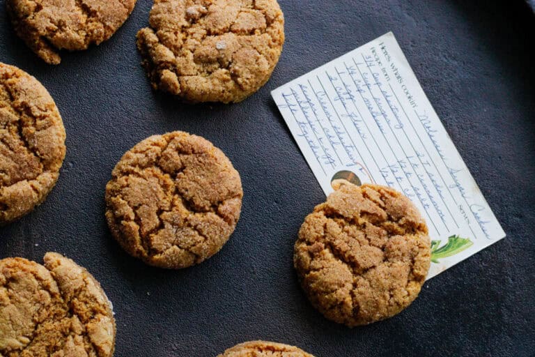 overhead view of chewy cinnamon orange almond flour cookies with a hand written old fashioned recipe card