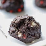 double chocolate cookie with white and cherry chips on a baking sheet