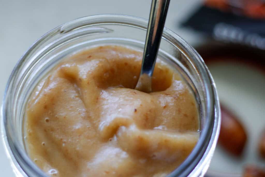 Close up on a brown thick date paste sweetener in a mason jar