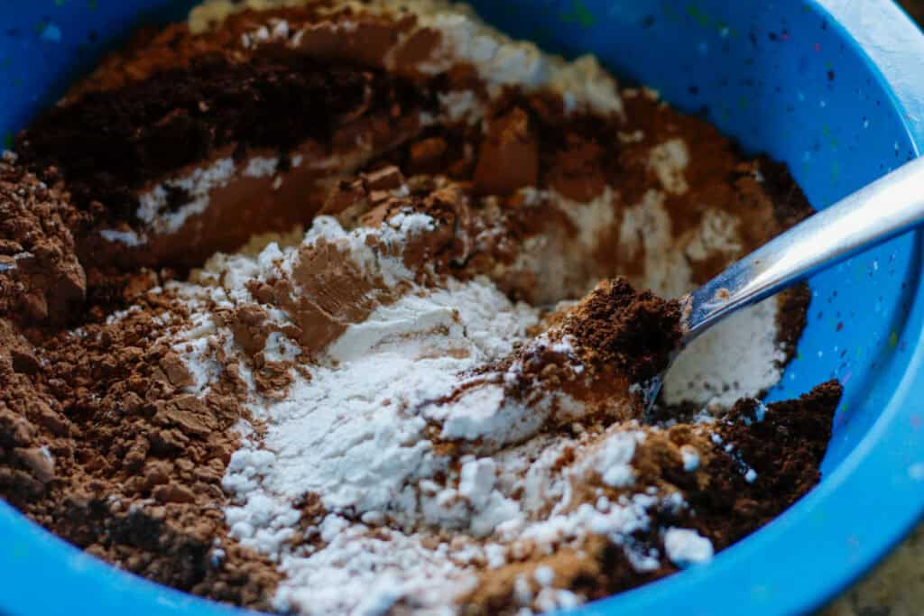 Blue mixing bowl filled with flour and cocoa powder