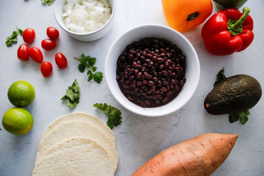 Ingredients for vegetarian sweet potato and black bean tacos laid out on a counter top.