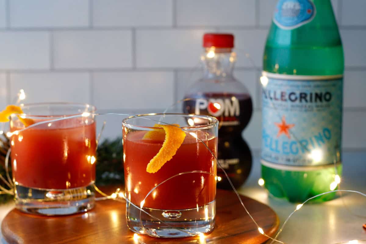 Sparkling mocktail on a tray with holiday lights