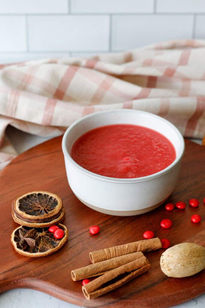 Bright red applesauce in a bowl on a serving tray
