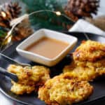 Crispy spaghetti squash bites with a side of maple aoli on a black serving dish