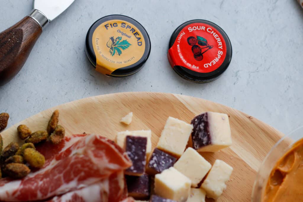 Part of a cheese board with caps for fig spread and sour cheery spread