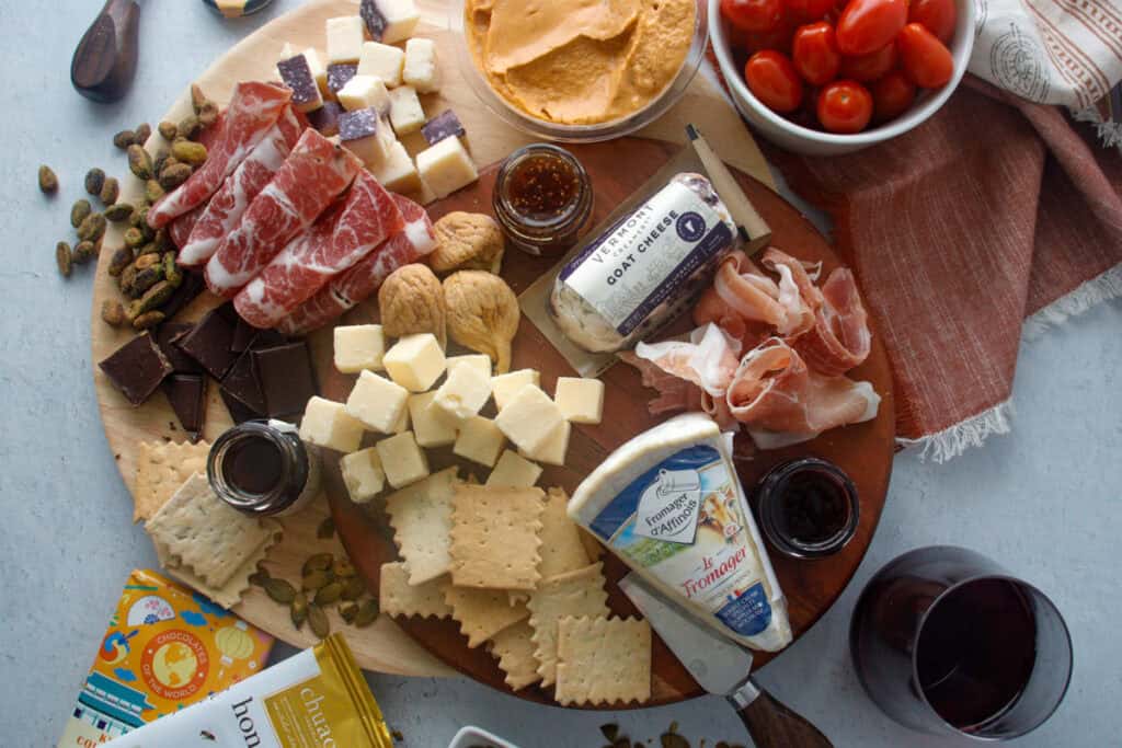 Curated cheese board with a mixture of cheeses, meats, chocolate, dips and crackers