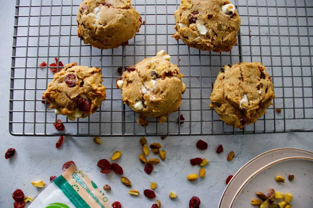 Golden chewy white chocolate cranberry pistachio cookies on a cooling rack