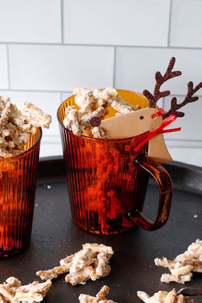 white chocolate pretzels in a cup with a holiday gift tag