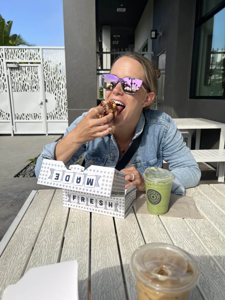 McKenzie creator of Time Stamped Food eating a donut in the california sun