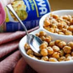 Hand spooning chickpea snack out of bowl