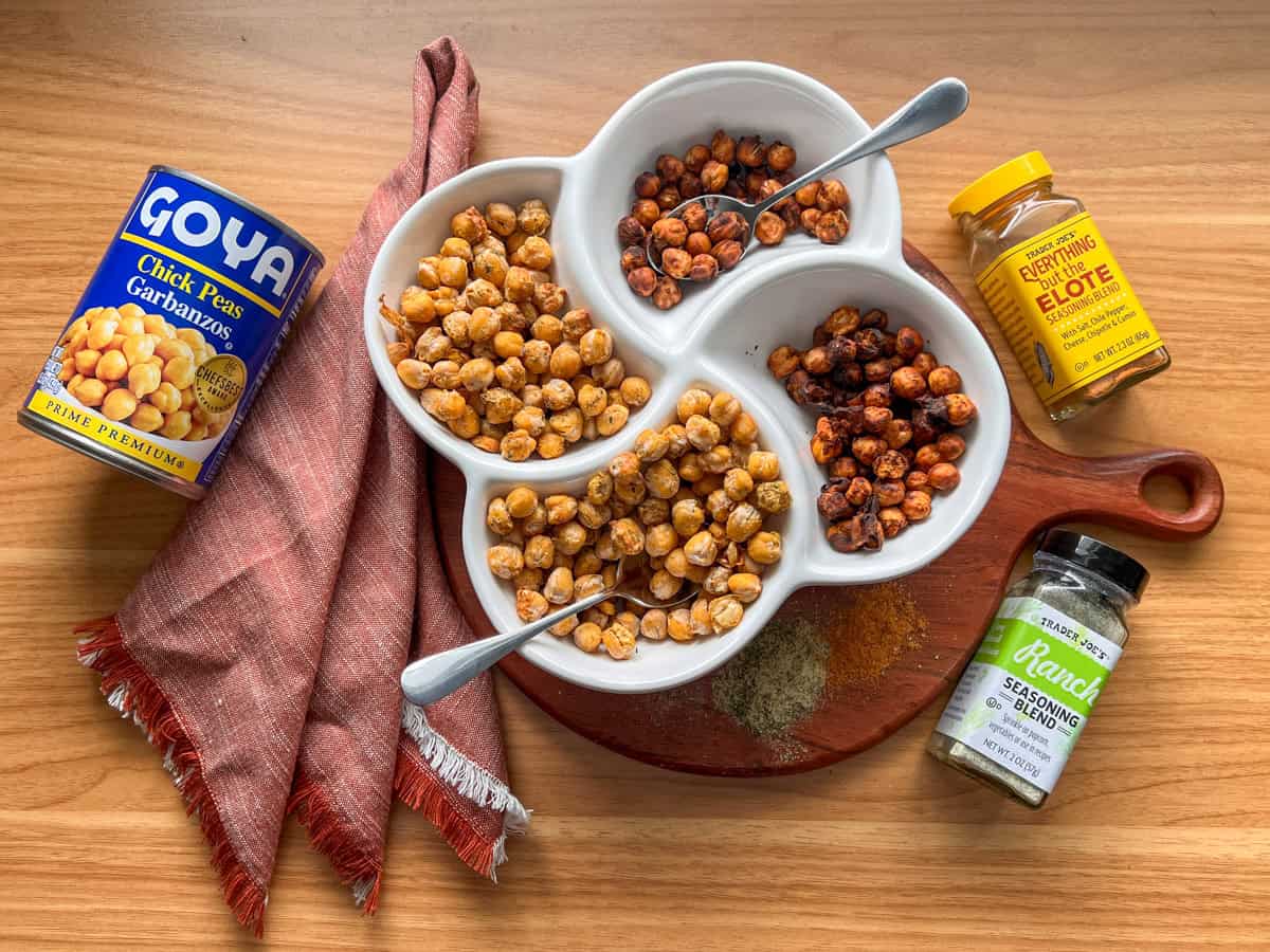Overhead of crispy chickpeas in a bowl and seasoning bottles