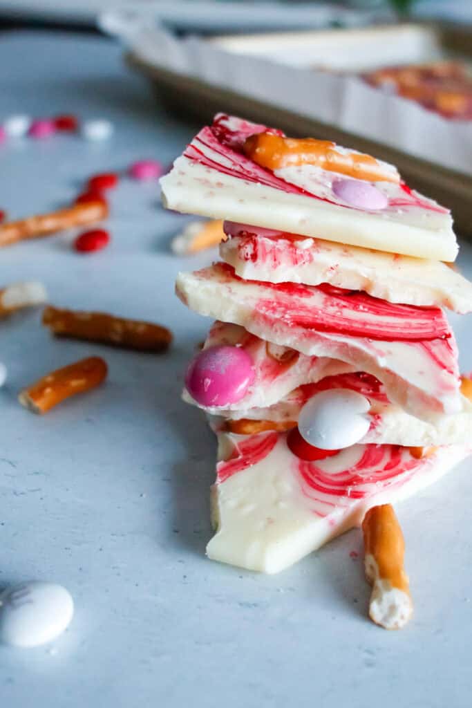 stack of white chocolate bark with pretzel bites, pink swirls and valentine's m&ms