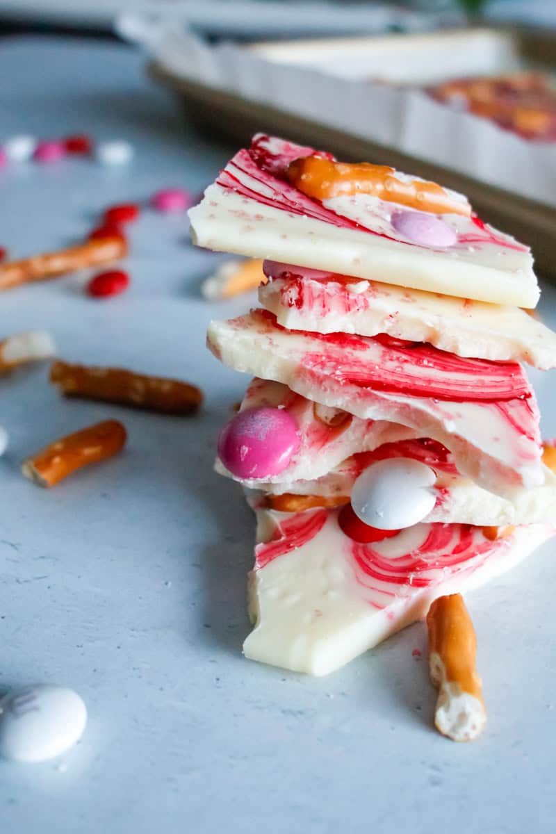 stack of white chocolate bark with pretzel bites, pink swirls and valentine's m&ms