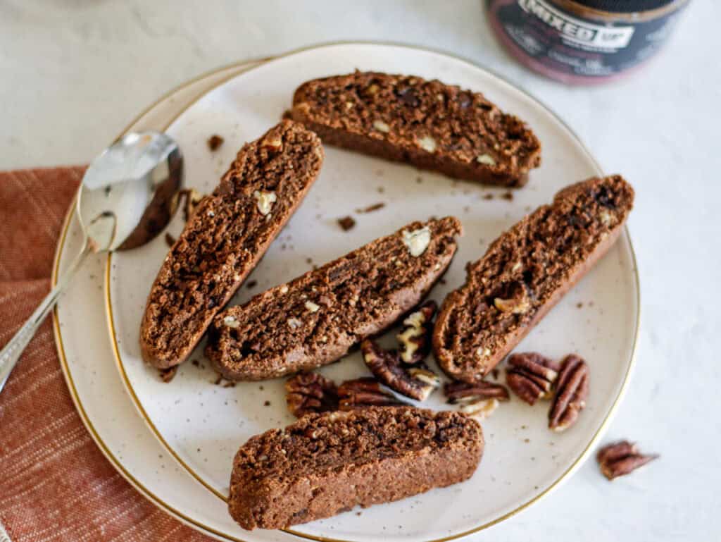Chocolate pecan biscotti with chunks of pecans, served on a white plate, perfect for coffee or tea. A delicious, crunchy treat made with rich chocolate and toasted pecans.