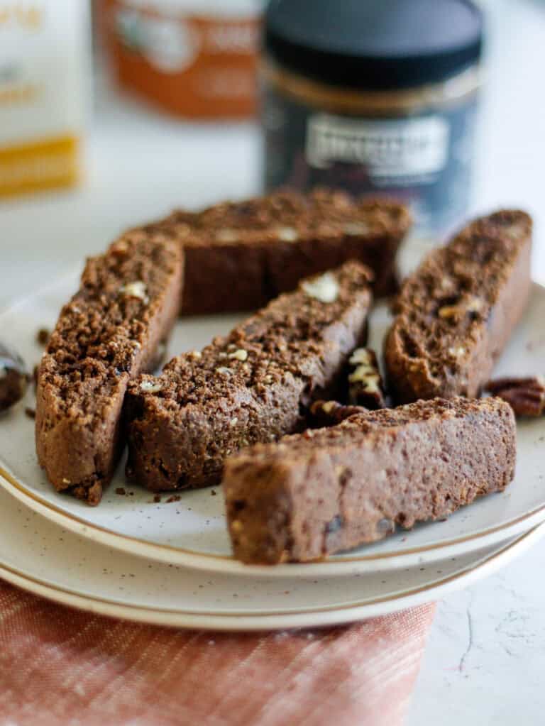 Rich chocolate biscotti with chopped nuts on a white plate.