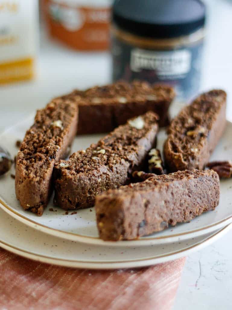 Rich chocolate biscotti with chopped nuts on a white plate.