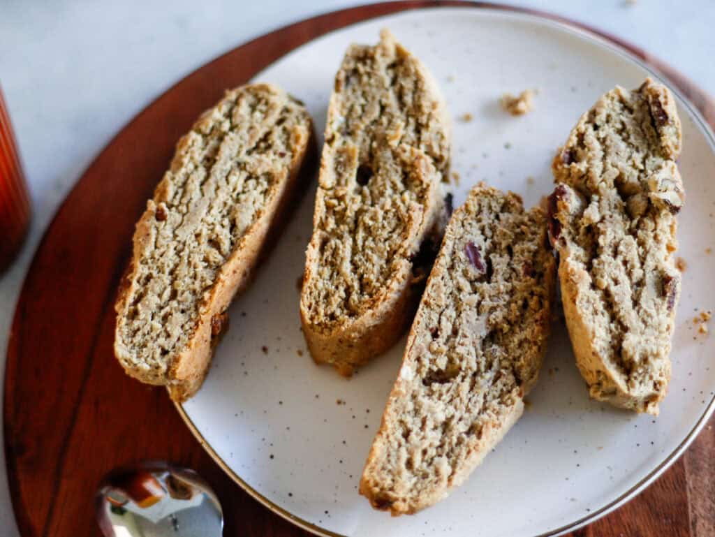 Rich biscotti with nuts and chocolate chunks, sliced and served on a white plate - perfect for coffee or tea.