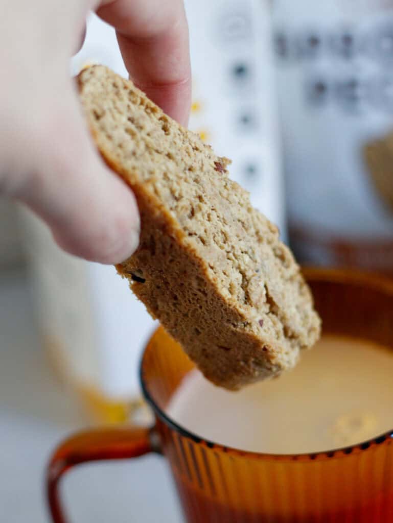 Soft oatmeal cookie dipped in warm milk, perfect for cozy breakfast or snack.