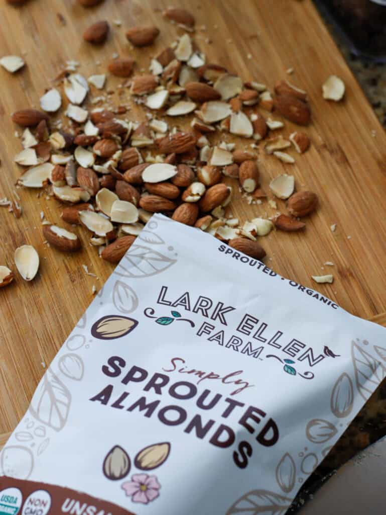 1. Organic sprouted almonds on wooden cutting board with almond packaging for healthy snacking and plant-based diet.