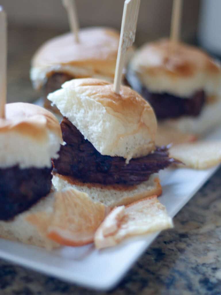 Juicy beef sliders with toasted buns, melted cheese, and crispy bacon on a serving platter, perfect for tasting events and appetizer platters, showcasing delicious gourmet appetizer ideas.