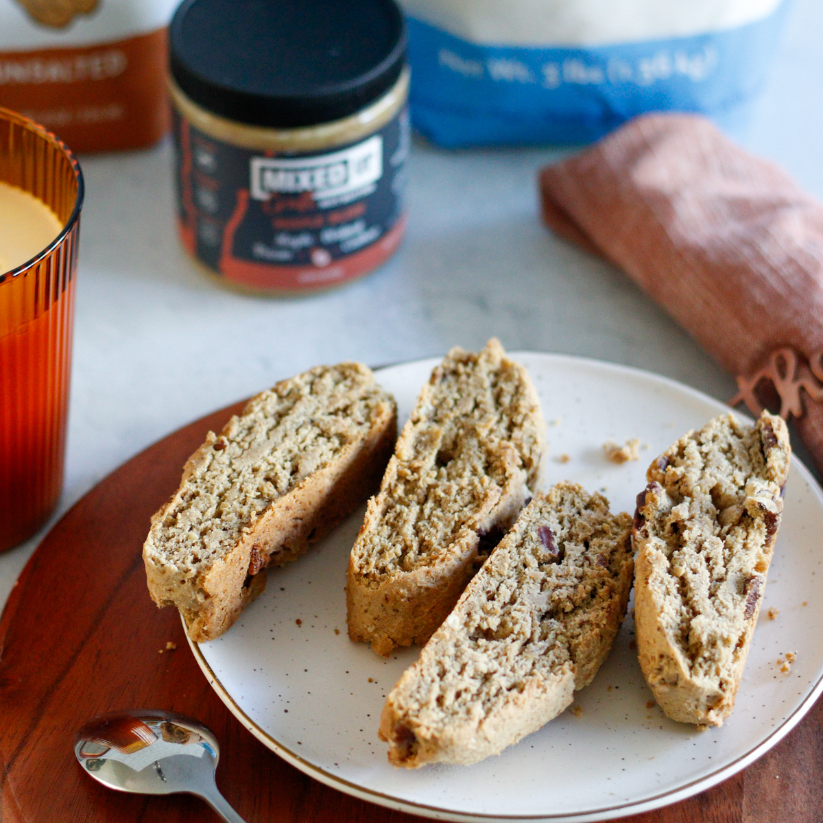Overhead of biscotti laying out on a white plate on a wood serving tray