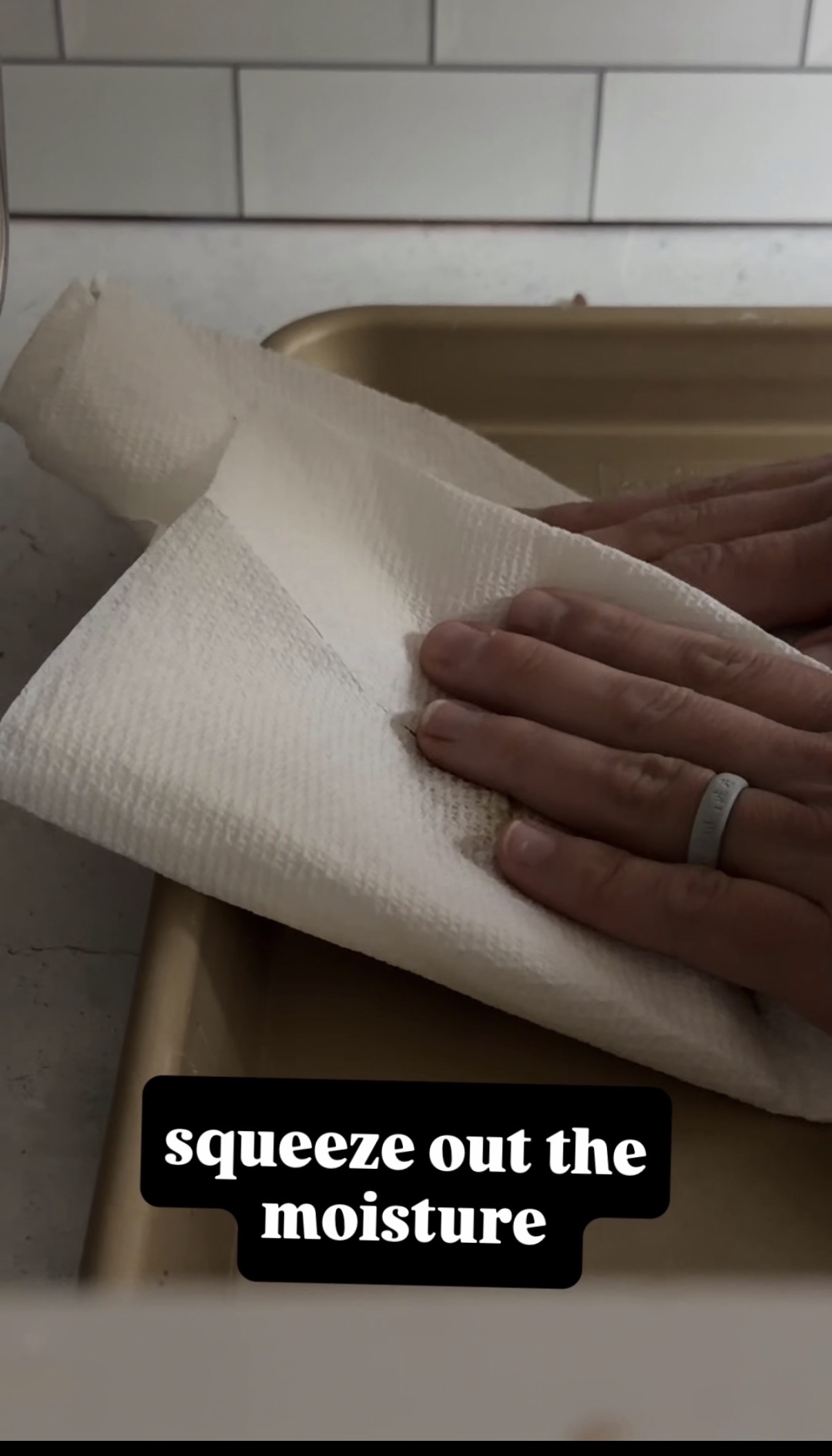squeezing out water from canned pumpkin with a paper towel