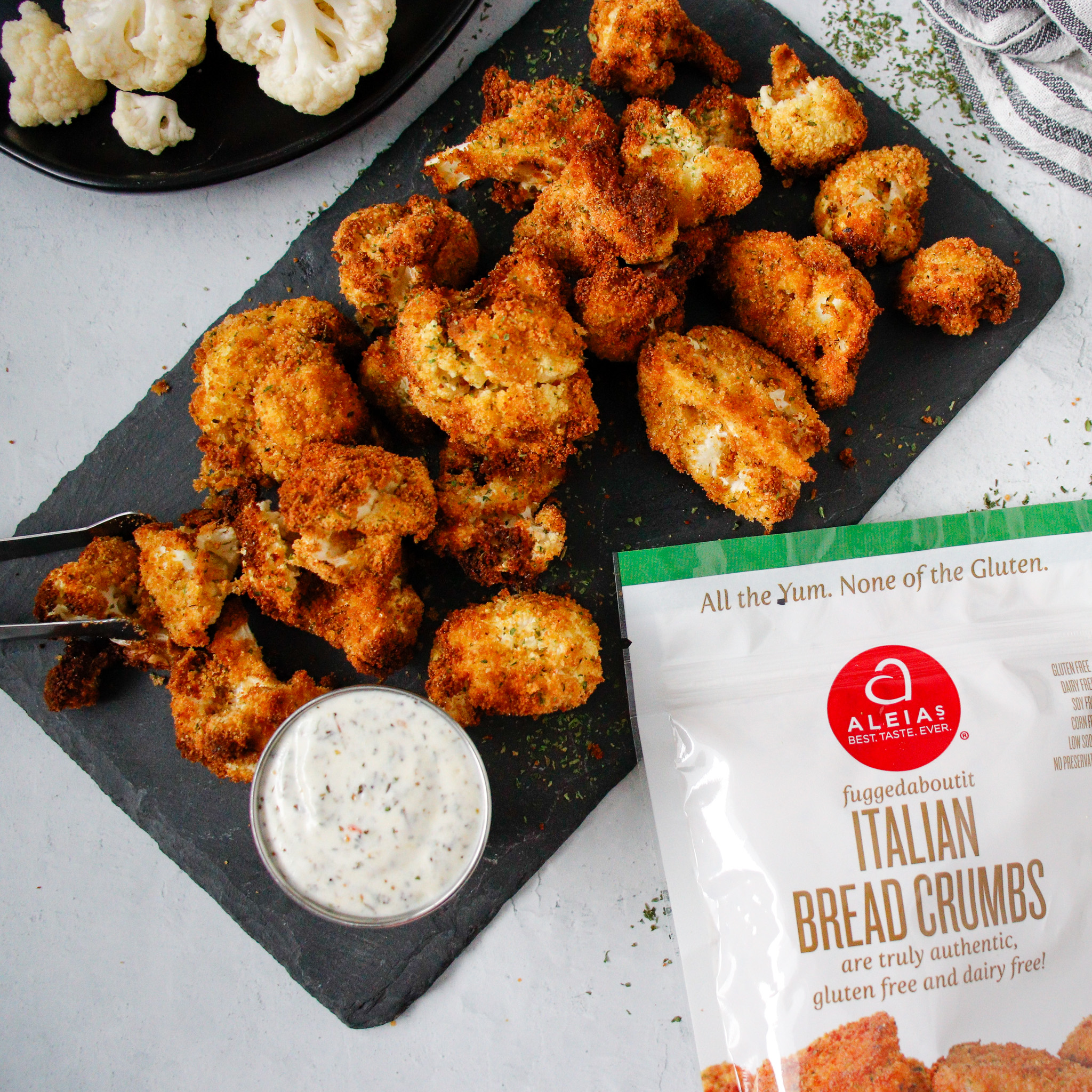 Overhead shot of crispy breaded cauliflower on a black serving tray