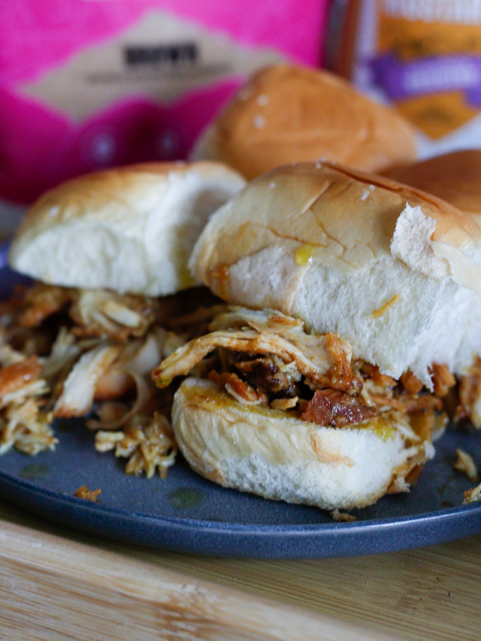 close up of shredded chicken pouring out of a slider bun