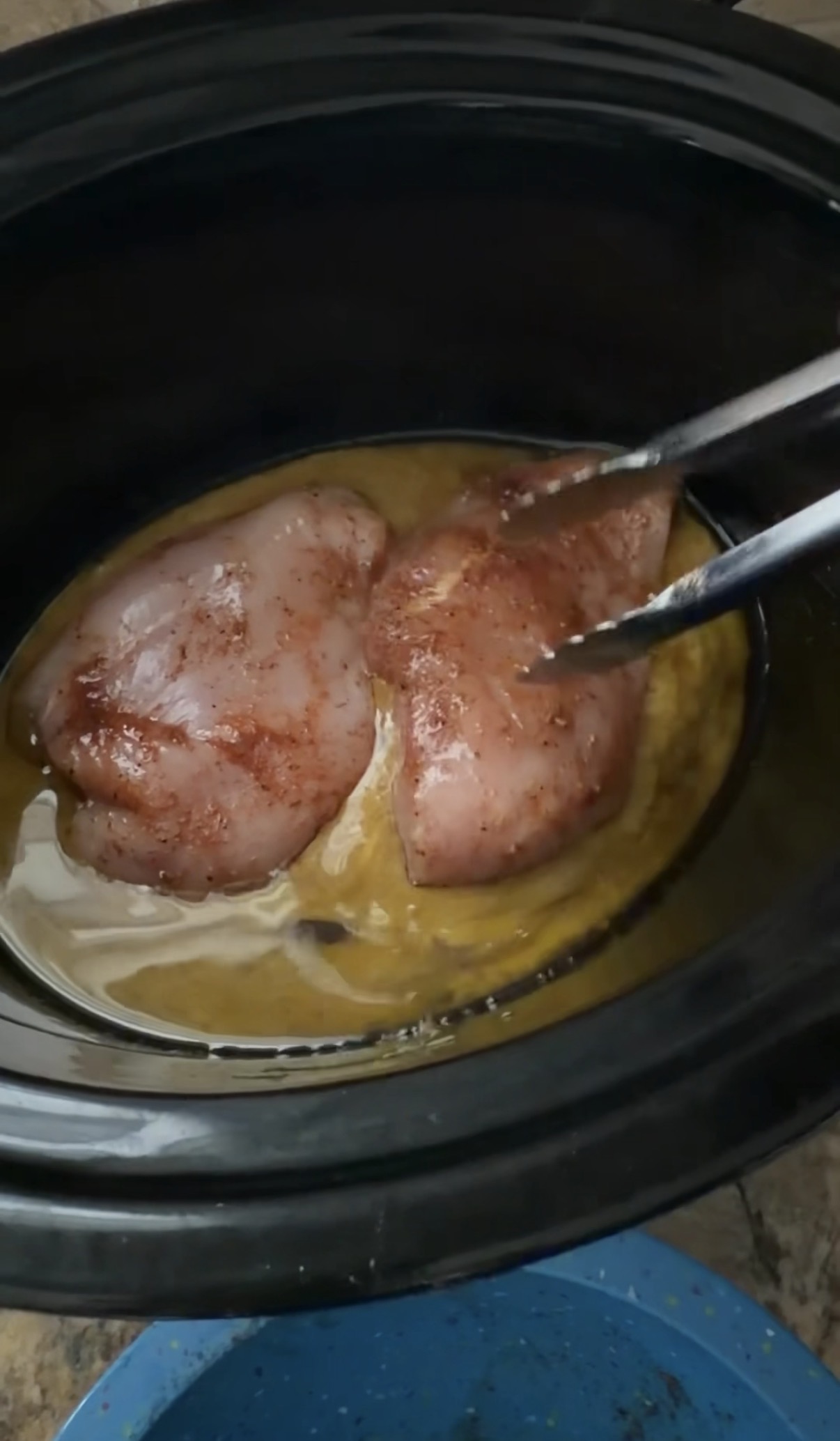 adding chicken to sauce in slow cooker